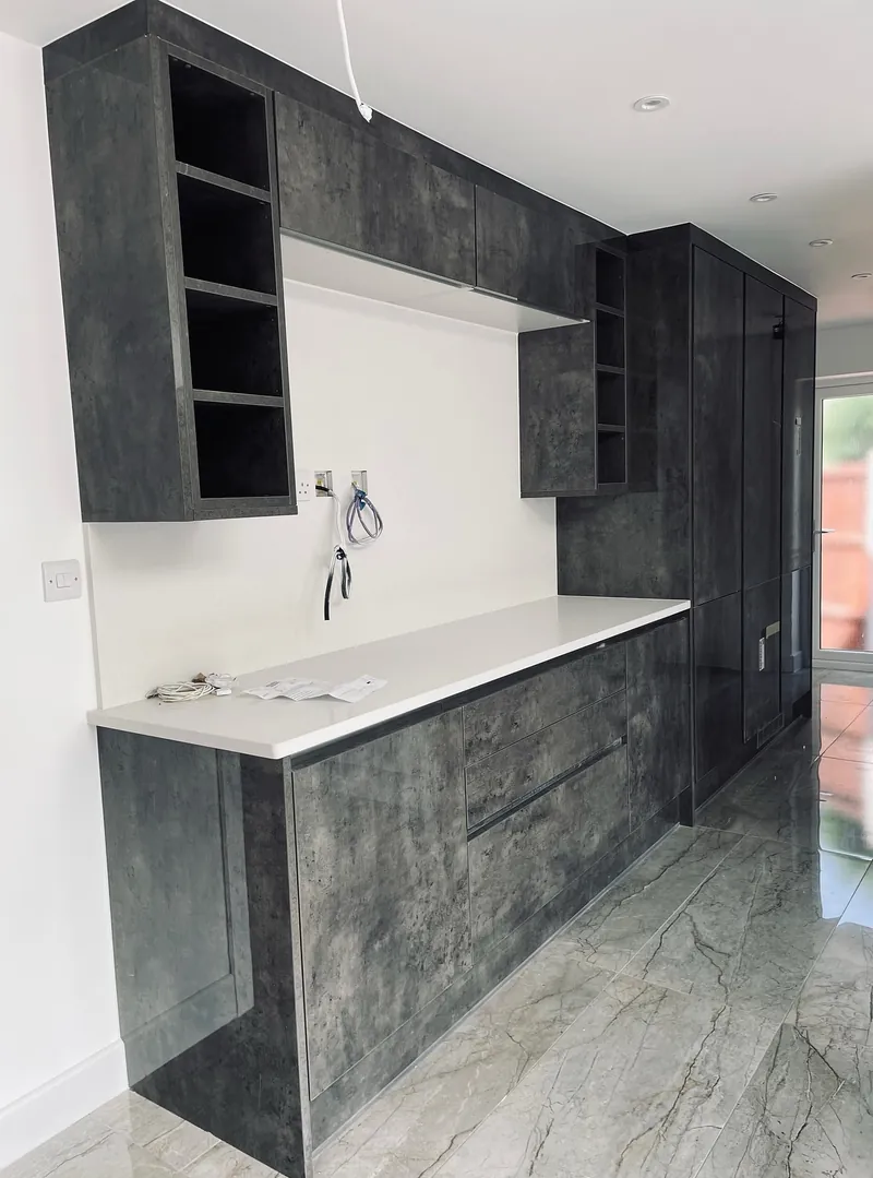 Grey kitchen units with a white worktop fitted in the Harrow bungalow